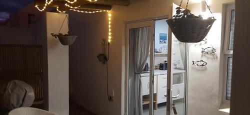 uma casa de banho com espelho e luzes na parede em Milk Thistle Loft & Studio apartments em Paternoster