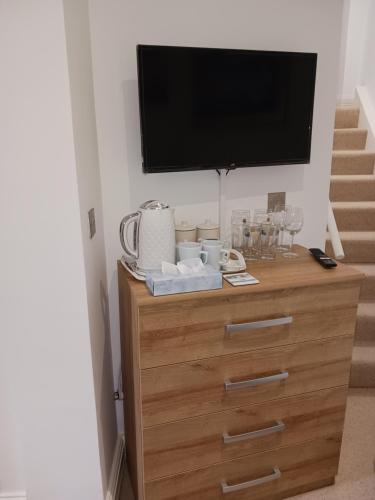 a dresser with a television on top of it at BODLONDEB CASTLE BED & BREAKFAST { CENTRAL LLANDUDNO} in Llandudno