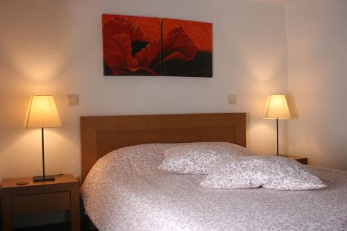 een slaapkamer met een bed met 2 lampen bij Casa do Pinto in Arouca