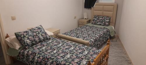 um pequeno quarto com 2 camas e um sofá em MALAK Tingis em Tânger