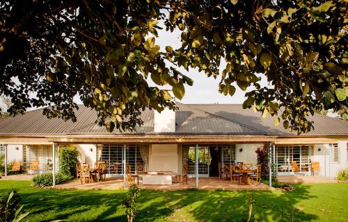 a house with a patio with tables and chairs at Katambuga House in Arusha