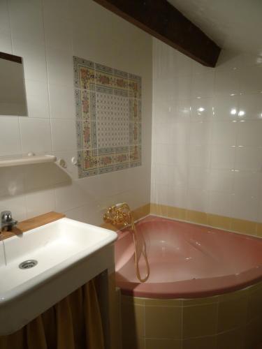 格霍皮耶的住宿－Chambres chez l habitant près de Vallon pont d Arc，一间带粉色浴缸和水槽的浴室
