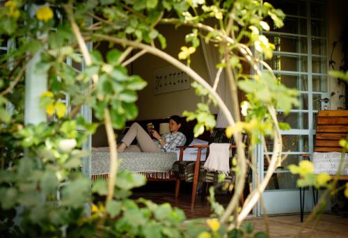 a woman sitting on a couch in a living room at Katambuga House in Arusha