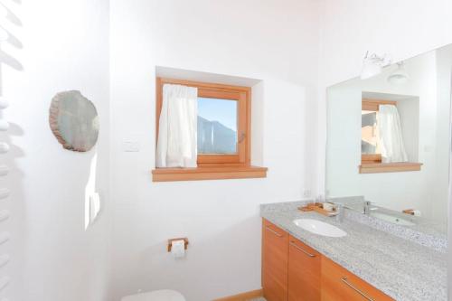 ピンツォーロにあるLovely apt in Pinzolo Val Rendena 6の白いバスルーム(シンク、鏡付)