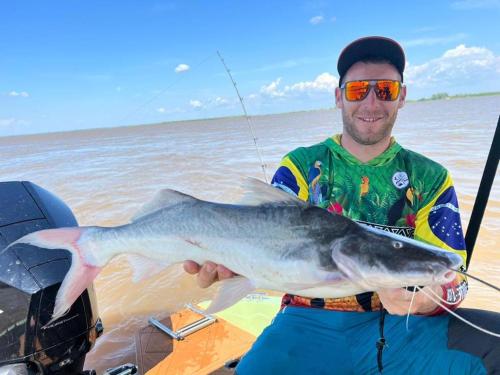 a man holding a large fish in his hand at River X House in Manaus