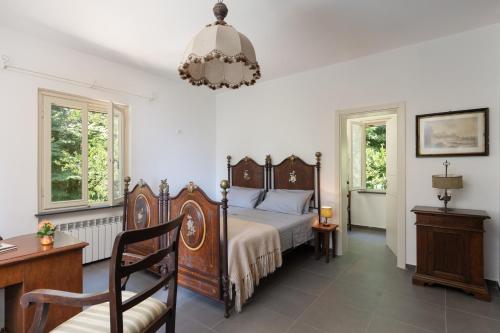 a bedroom with a bed and a chair and windows at Casa Sul Serra in Calci
