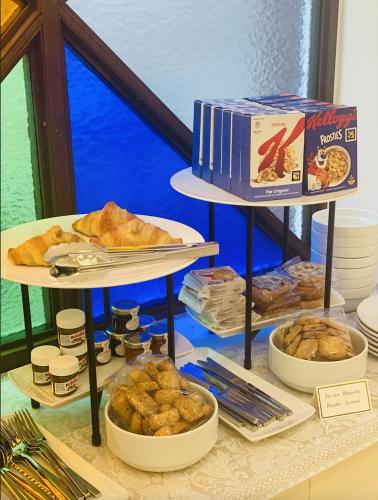 un tavolo sormontato da tre piani di pasticcini e pane di Corvaja Inn a Taormina