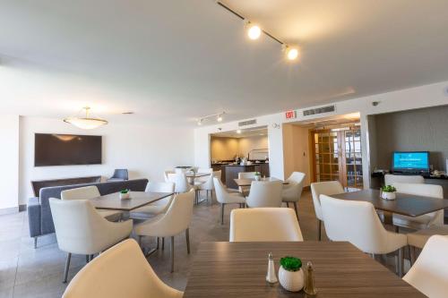 a dining room with tables and white chairs at DoubleTree by Hilton Dallas/Richardson in Richardson