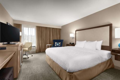 Habitación de hotel con cama grande y TV de pantalla plana. en Hampton Inn Georgetown-Marina, en Georgetown