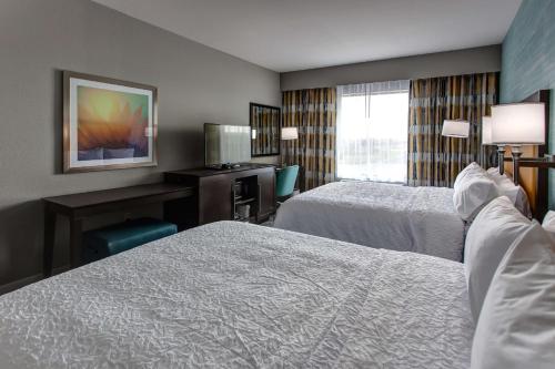 a hotel room with two beds and a desk at Hampton Inn & Suites-Wichita/Airport, KS in Wichita
