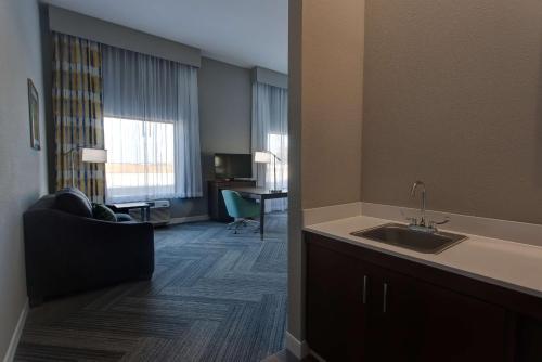 Hampton Inn & Suites-Wichita/Airport, KS في ويتشيتا: غرفة في الفندق مع حوض وغرفة معيشة