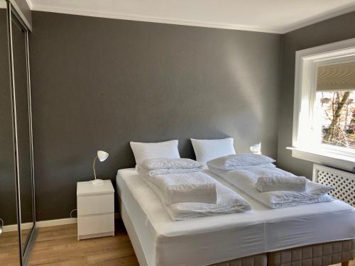 a bedroom with a bed with white sheets and pillows at Majorstua, charming and modern 2 bedroom apartment in Oslo