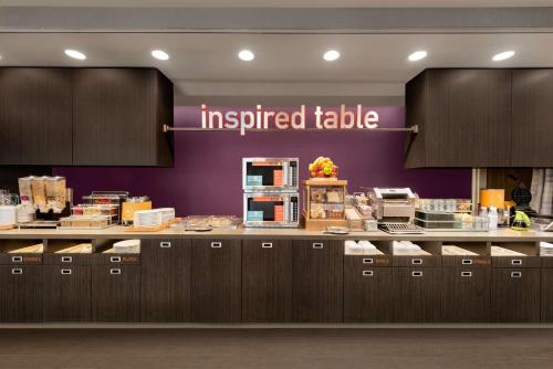 una cucina con un tavolo ispirato in un ristorante di Home2 Suites By Hilton Menomonee Falls Milwaukee a Menomonee Falls