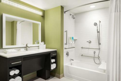 a bathroom with a sink and a tub and a shower at Home2 Suites By Hilton Menomonee Falls Milwaukee in Menomonee Falls