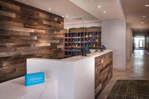 a lobby with a reception counter with wooden walls at Home2 Suites By Hilton Riverside March Air Force Base, Ca in Riverside