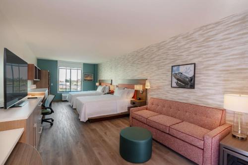 une chambre d'hôtel avec un lit et un canapé dans l'établissement Home2 Suites By Hilton Riverside March Air Force Base, Ca, à Riverside