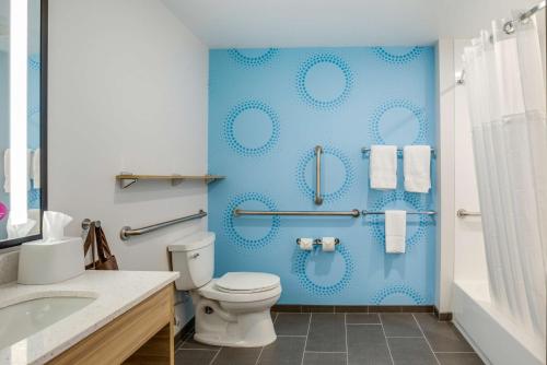 baño con aseo y pared azul en Tru By Hilton Saint Joseph, en Stevensville