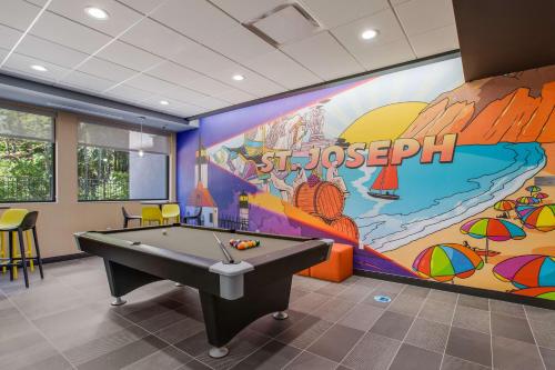 a pool table in a room with a large mural at Tru By Hilton Saint Joseph in Stevensville
