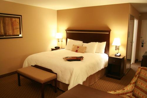 a hotel room with a large bed with a tray on it at Hampton Inn Topeka in Topeka