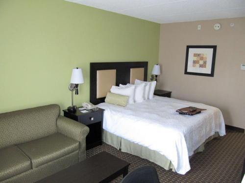 a hotel room with a bed and a chair at Hampton Inn Lindale/Tyler in Lindale