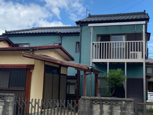 a house with a balcony in front of it at 民泊　筑紫野 in Chikushino