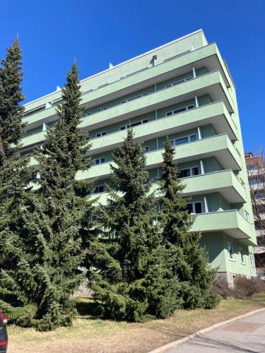 a tall apartment building with trees in front of it at Majorstua, charming and modern 2 bedroom apartment in Oslo