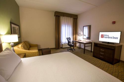 a hotel room with a bed and a television at Hilton Garden Inn State College in State College