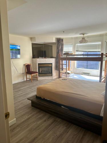 um quarto com uma cama grande e uma lareira em Western Budget Motel East Red Deer em Red Deer