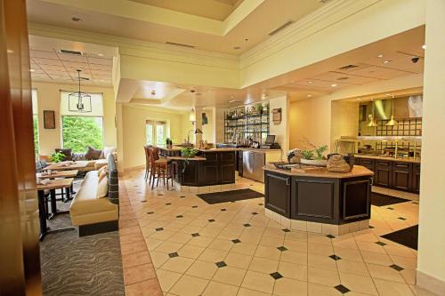 a large kitchen and living room with a couch and tables at Hilton Garden Inn State College in State College