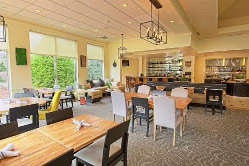 a restaurant with tables and chairs and a bar at Hilton Garden Inn State College in State College