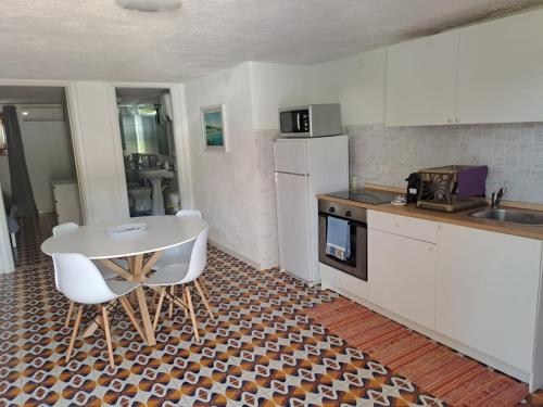 a kitchen with a table and a white table and chairs at Villa Rita Apartment in Fontane Bianche
