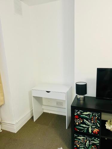 Centrally located modern flat في لندن: مكتب أبيض في غرفة مع تلفزيون