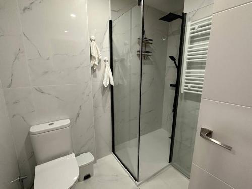 ein Bad mit einem WC und einer Glasdusche in der Unterkunft Apartamento acogedor , Blanes in Blanes