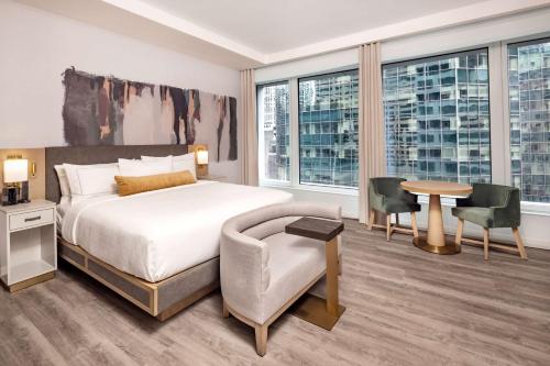 een hotelkamer met een bed en een tafel en stoelen bij Hilton Club The Central at 5th New York in New York