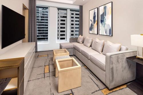 a living room with a couch and a flat screen tv at Hilton Club The Central at 5th New York in New York