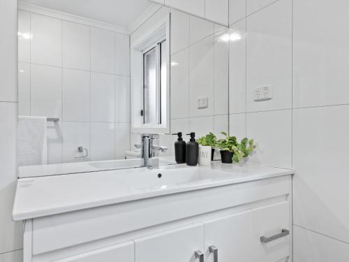 Baño blanco con lavabo y espejo en PRIVATE ROOM 4 and PRIVATE ROOM 5 beside Monash University in Clayton, en Clayton North
