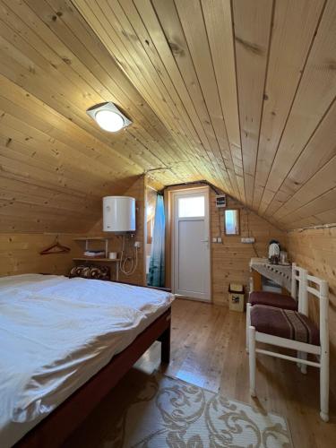 sypialnia z łóżkiem i drewnianym sufitem w obiekcie Homestay Djerkovic w mieście Žabljak
