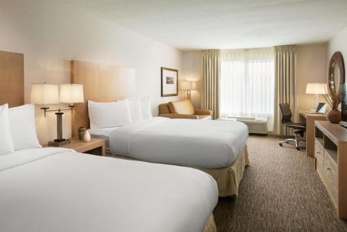 a hotel room with two beds and a desk at DoubleTree by Hilton Vancouver in Vancouver