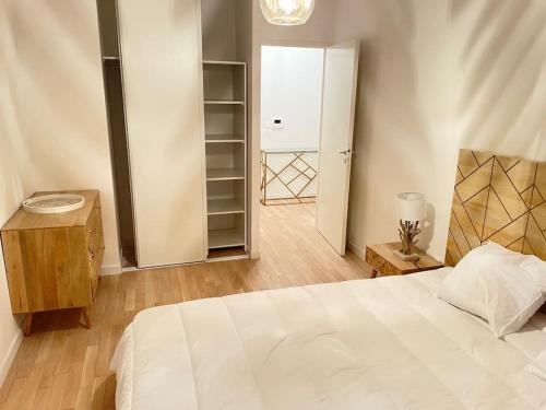 um quarto com uma cama branca e um closet em Appartement 4P U Arena em Nanterre