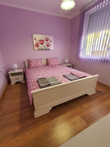 a bedroom with a large bed with a pink bedspread at Нощувки Краткосрочен наем in Plovdiv