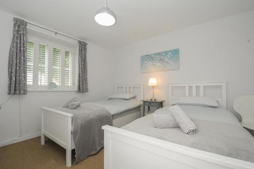 a bedroom with two beds and a window at Weasels Nest in Bodmin