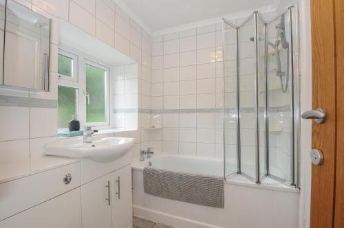 a white bathroom with a sink and a shower at Weasels Nest in Bodmin