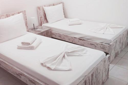 2 Betten mit weißer Bettwäsche und Handtüchern darauf in der Unterkunft Zorbas House in Iraklio