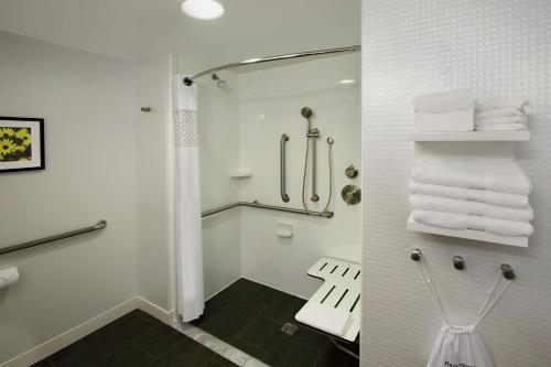 a bathroom with a shower and a toilet with towels at Hampton Inn Hagerstown-Maugansville in Hagerstown
