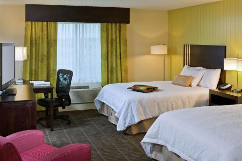 Un pat sau paturi într-o cameră la Hampton Inn & Suites Saginaw