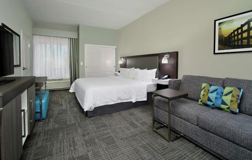 a hotel room with a bed and a couch at Hampton Inn Hagerstown-Maugansville in Hagerstown