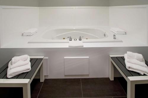 a white bathroom with a tub and two towels at Hampton Inn Hagerstown-Maugansville in Hagerstown