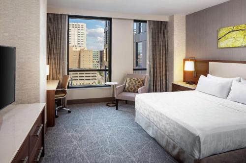 a hotel room with a bed and a large window at Hilton Rochester Mayo Clinic Area in Rochester
