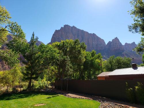 a backyard with a fence and mountains in the background at Cliffrose Springdale, Curio Collection By Hilton in Springdale