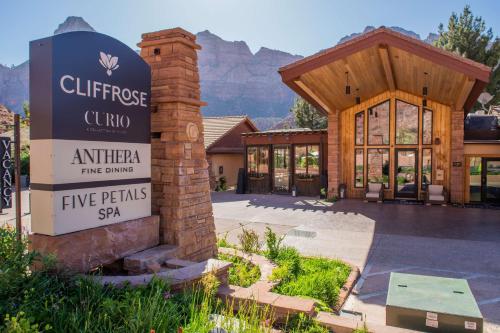 a sign in front of a building with mountains in the background at Cliffrose Springdale, Curio Collection By Hilton in Springdale